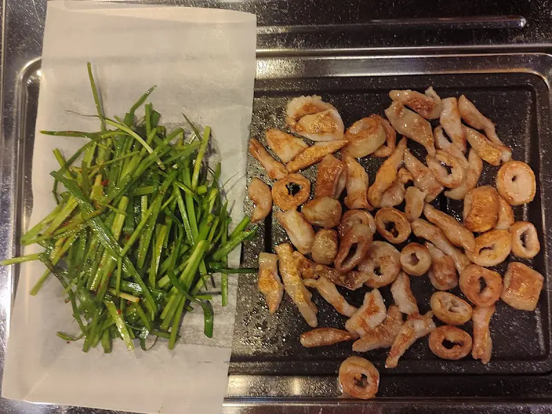 잘 구워진 막창과 싱싱한 부추