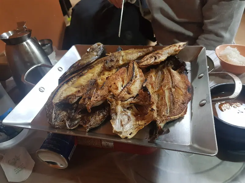 불판 위에 올려진 생선구이와 솥밥
