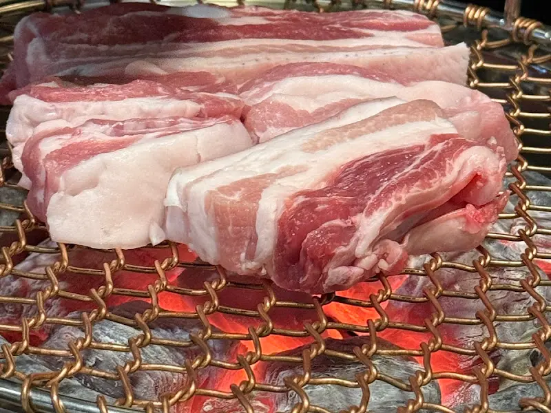 숯불 위에서 노릇하게 구워진 흑돼지