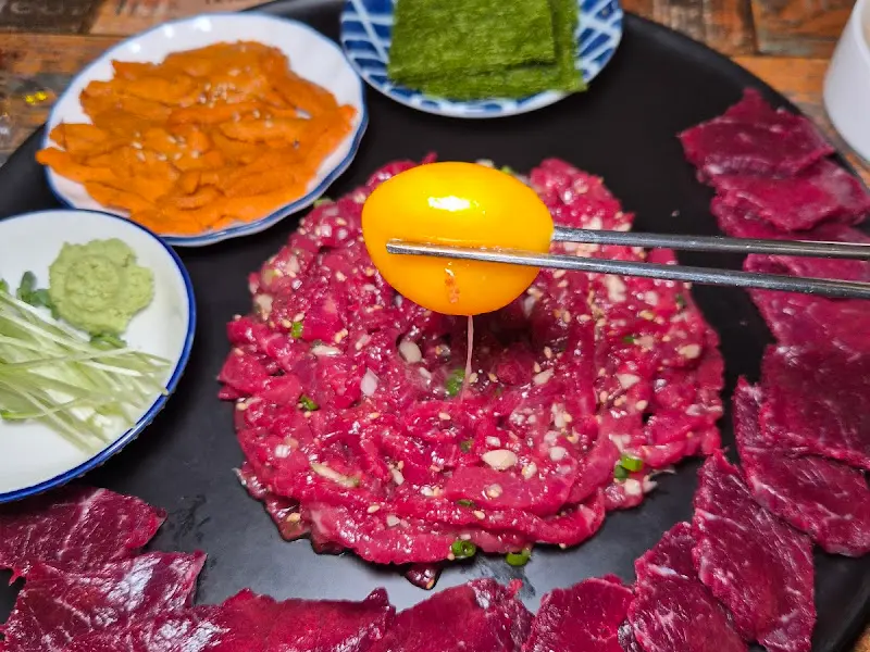 육회 위에 노른자를 올리는 모습