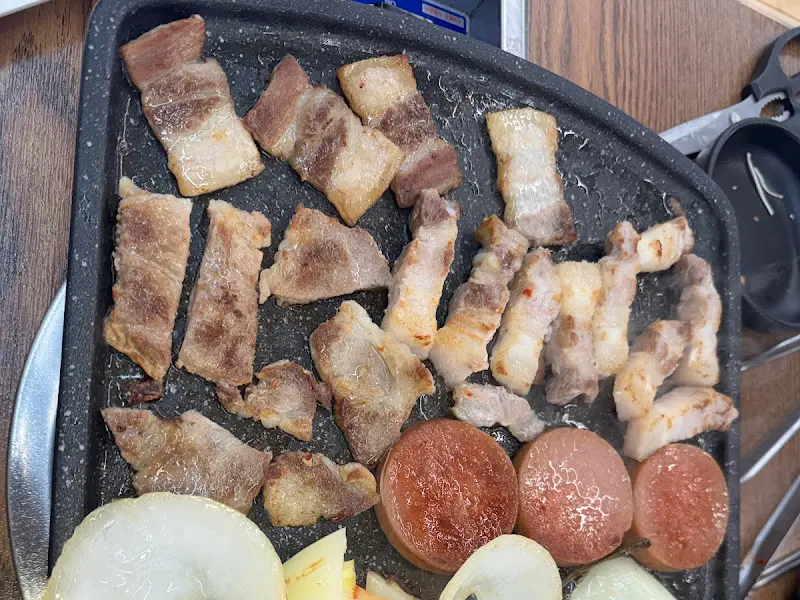 불판 위에 김치, 콩나물, 마늘, 양파 등을 함께 구워먹는 모습