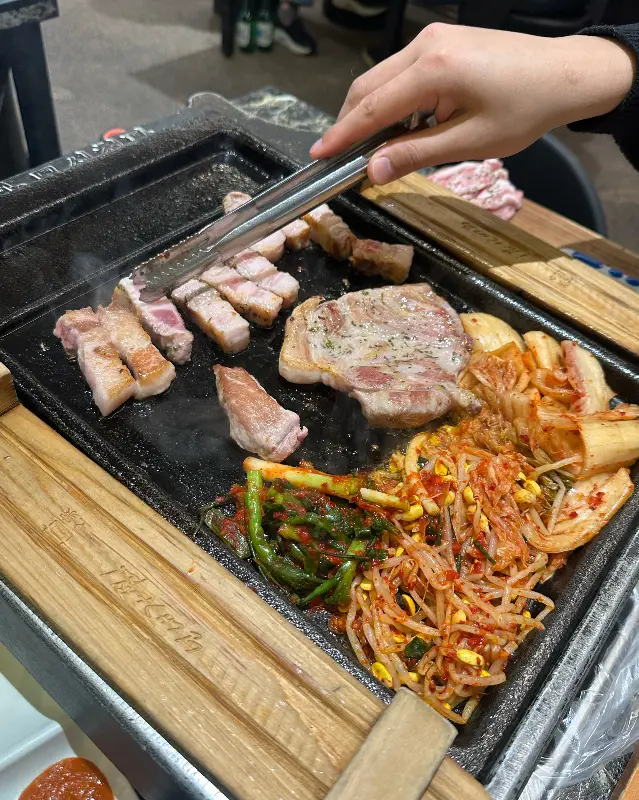 김치, 콩나물, 마늘과 함께 구워지는 삼겹살