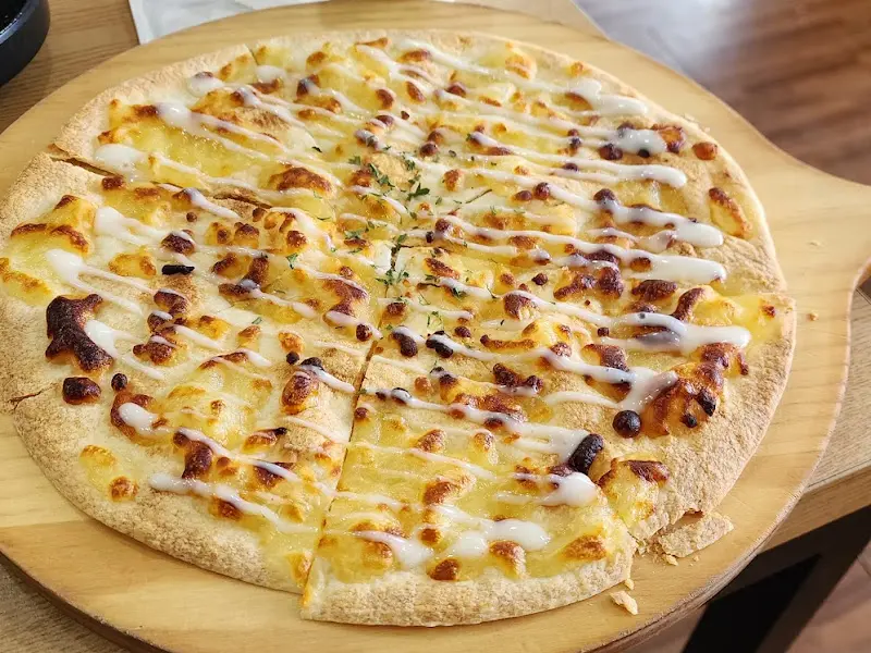 얇은 도우에 치즈가 듬뿍 올려진 피자