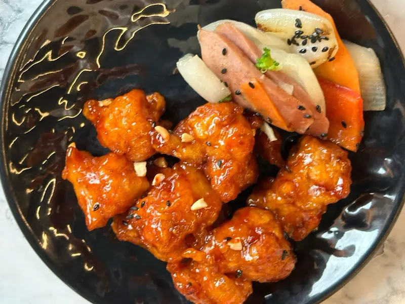 검은 접시에 담긴 닭강정과 샐러드