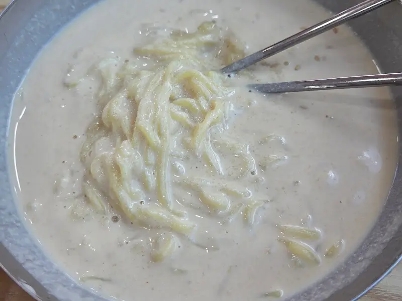 뽀얀 콩국물이 담긴 그릇에 면이 잠겨 있는 모습