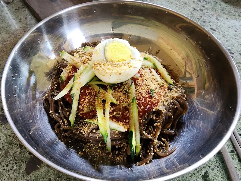 검은 면과 고명이 올려진 음식