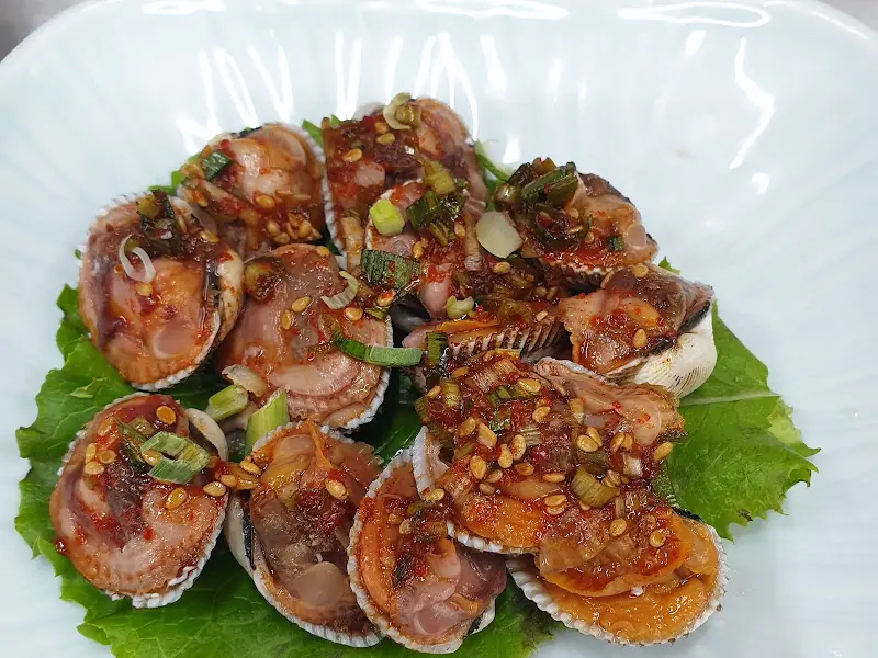 싱싱한 꼬막에 양념을 얹어 놓은 모습