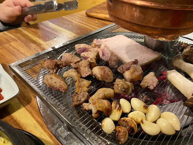 불판 위에 구워진 삼겹살과 버섯