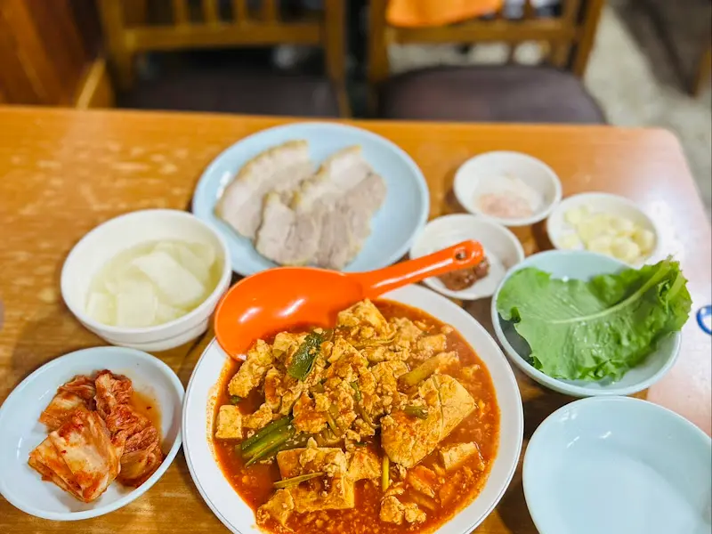 두부두루치기, 수육, 김치, 쌈채소 등이 한 상 가득 차려진 모습