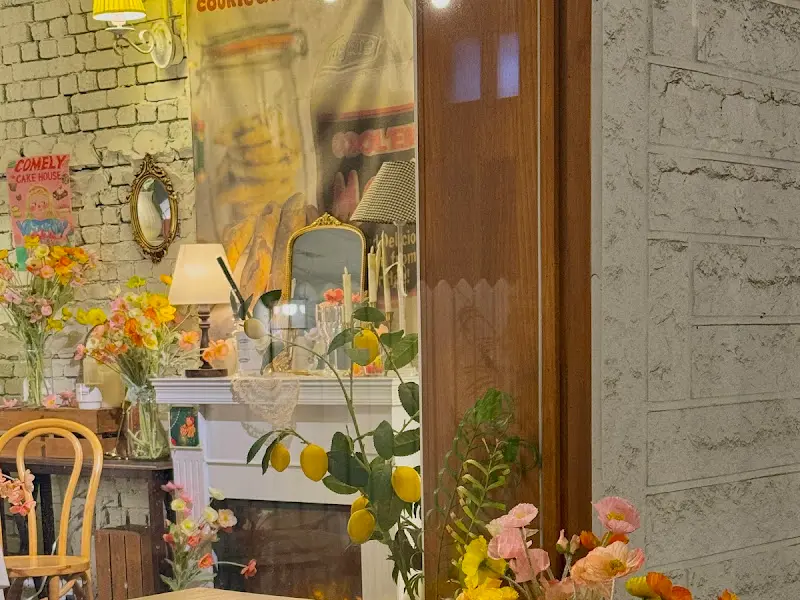 앤티크한 장식장과 꽃, 거울, 램프가 조화롭게 놓인 인테리어