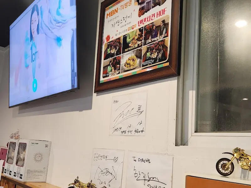 덴데치킨 내부 벽면에 걸린 방송 출연 사진과 싸인들