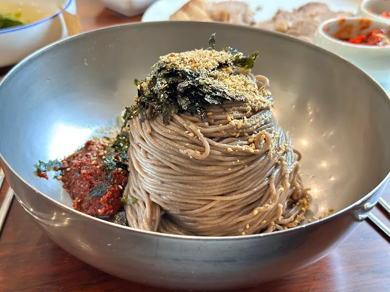 메밀 면 위에 김가루와 깨소금이 듬뿍 뿌려진 막국수