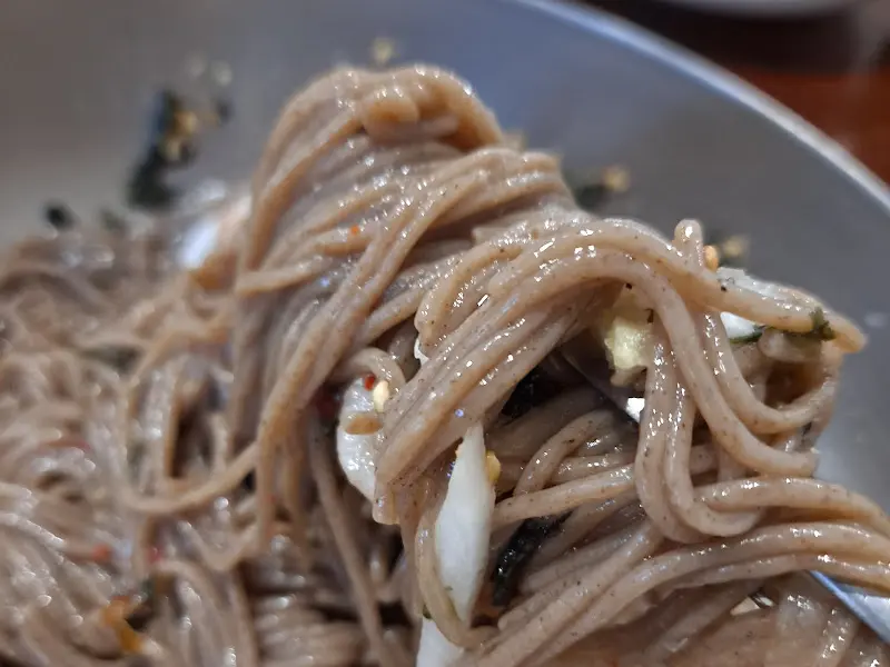 젓가락으로 집어 올린 막국수 면