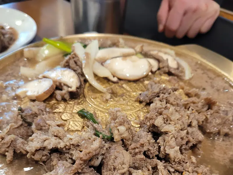 불판 위에 가득 올려진 불고기, 양파, 버섯의 모습