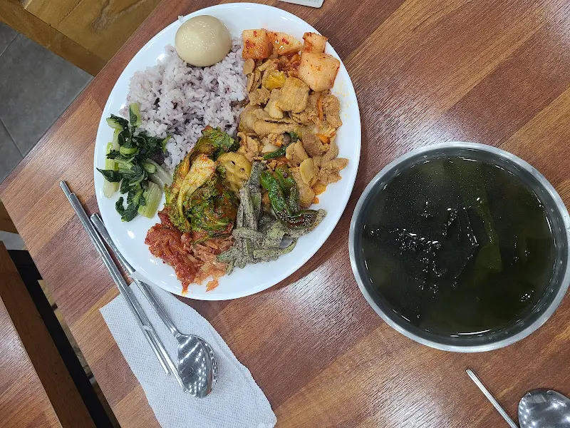 흑미밥과 다양한 반찬, 미역국이 담긴 접시