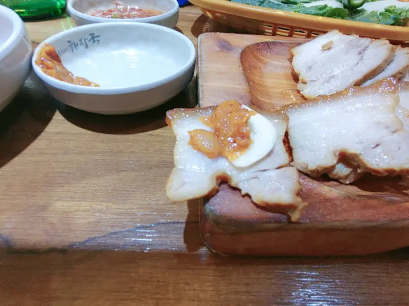 수육 한 점에 김치를 얹어 먹는 모습