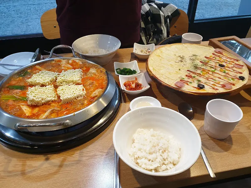 피자와 부대찌개가 함께 놓인 테이블