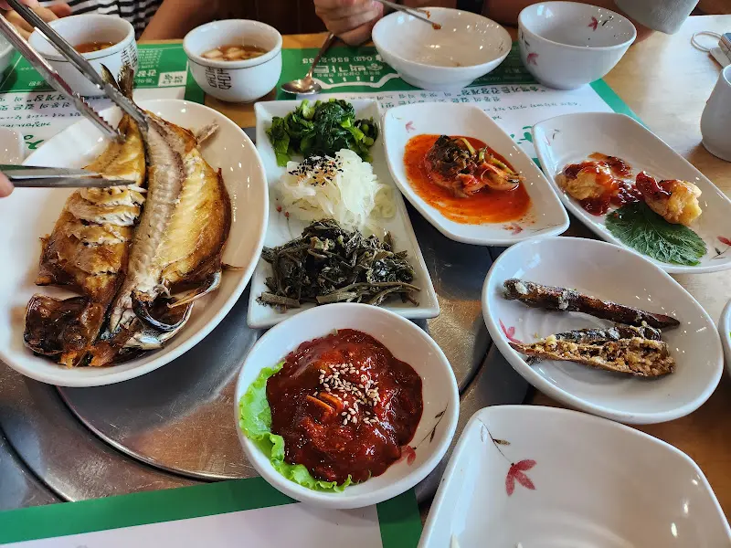 고등어 구이와 다양한 나물 반찬들이 놓여진 테이블