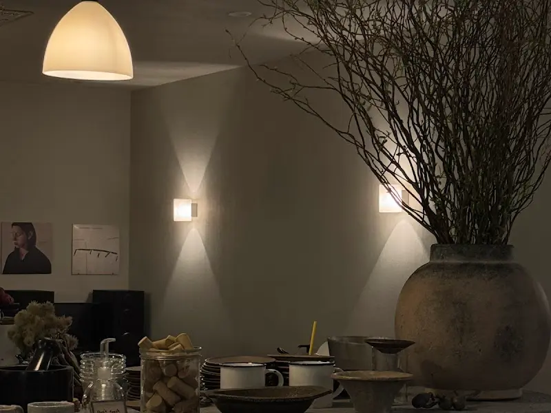 따뜻한 조명 아래 놓인 테이블과 그 옆에 놓인 화분