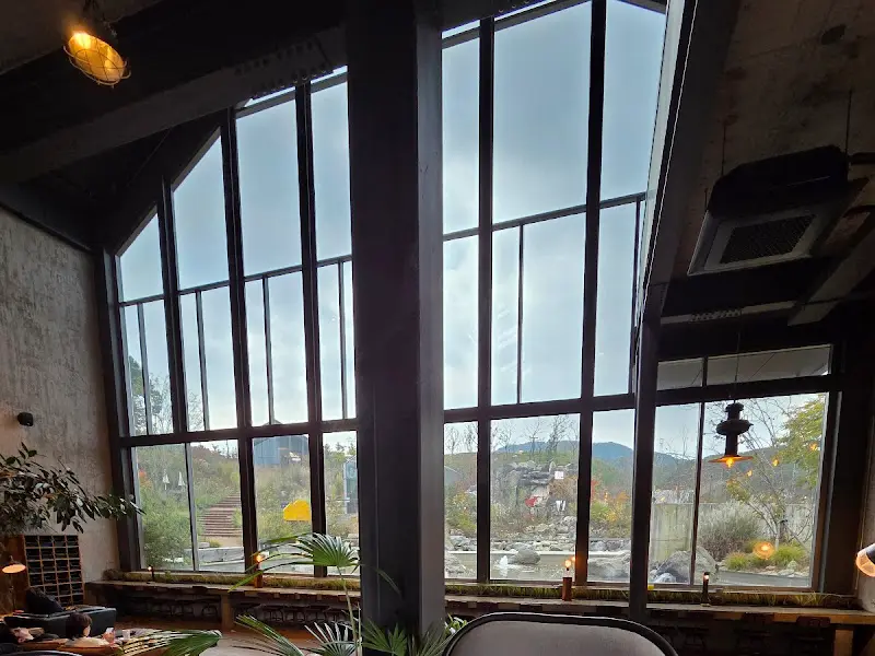 높은 천장과 넓은 창이 인상적인 카페 내부