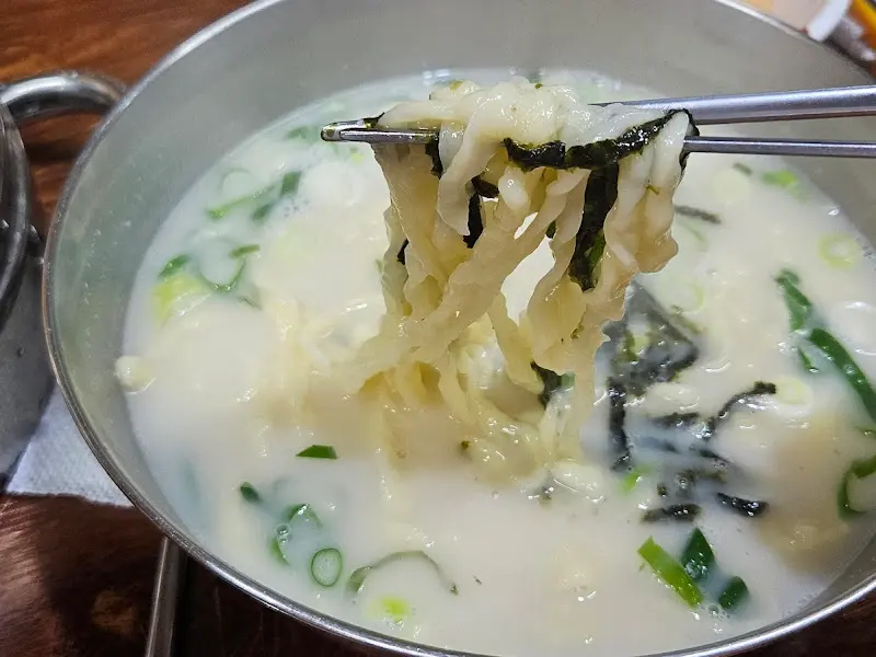 닭칼국수의 쫄깃한 면발을 젓가락으로 들어올린 모습