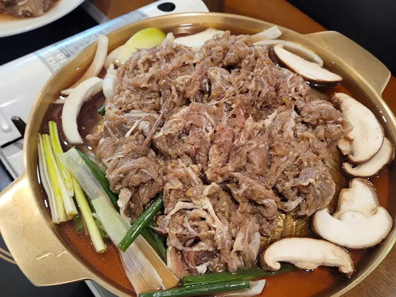 불판 위에 양파, 버섯과 함께 올려진 불고기의 모습