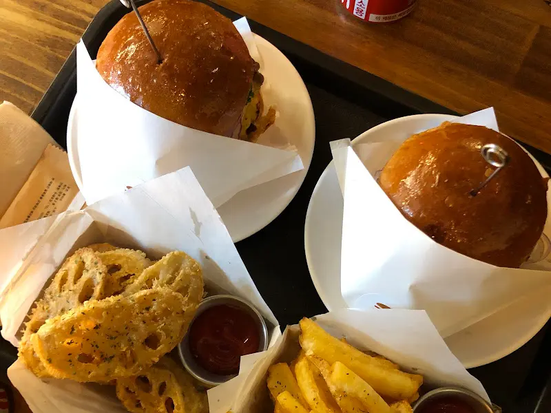 두 개의 햄버거와 연근 튀김, 감자 튀김이 놓인 쟁반