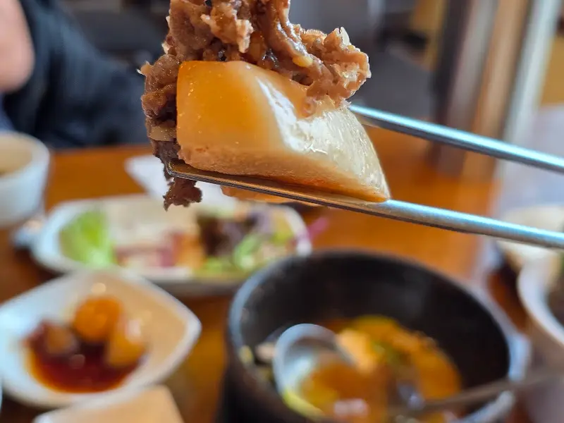 젓가락으로 버섯과 불고기를 함께 집어 올린 모습