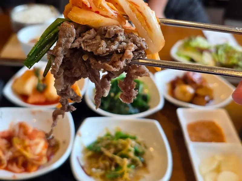 젓가락으로 불고기와 김치를 함께 집어 올린 모습