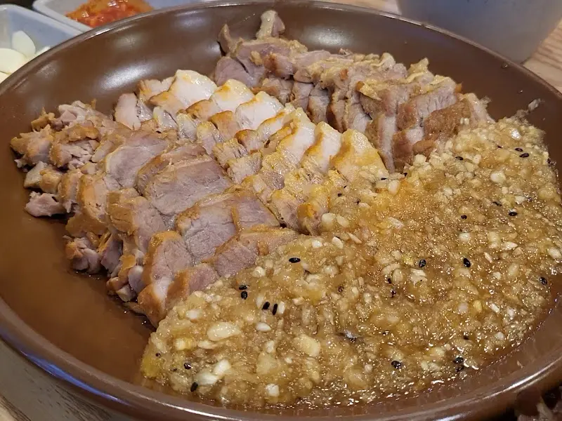 마늘 소스가 듬뿍 올려진 보쌈의 클로즈업