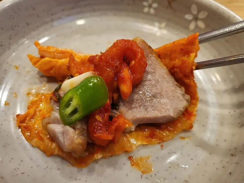 보쌈과 김치, 고추 등을 함께 싸 먹는 모습