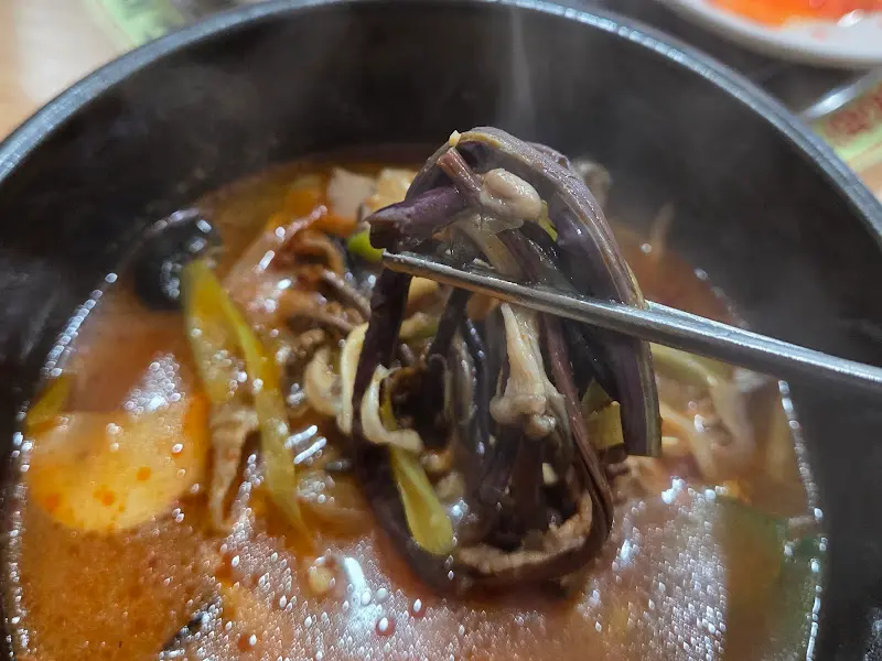 젓가락으로 집어 올린 우신탕 속 야채