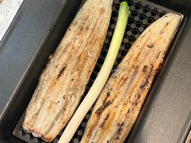 숯불 위에서 구워지고 있는 장어와 대파