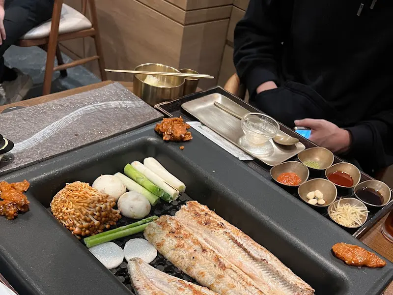 숯불 위에서 구워지고 있는 장어, 버섯, 떡, 마늘