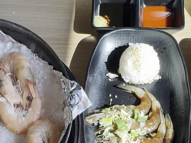 간장 새우와 밥이 검정색 그릇에 담겨 있는 모습