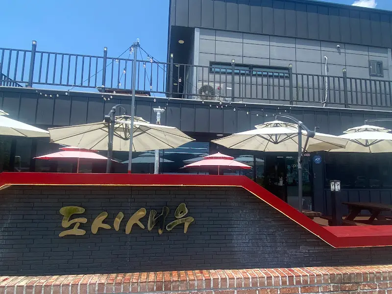 벽돌담 위에 도시새우라고 적힌 간판의 모습