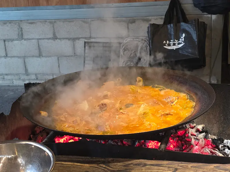 장작불 위에서 끓고 있는 솥뚜껑 닭볶음탕
