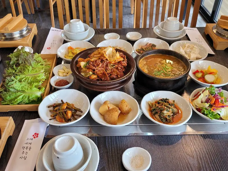 오리 로스와 다양한 반찬들이 한 상 가득 차려진 모습