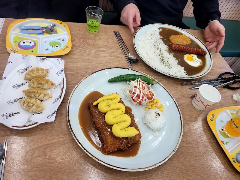 돈까스, 튀김, 만두가 함께 놓인 테이블