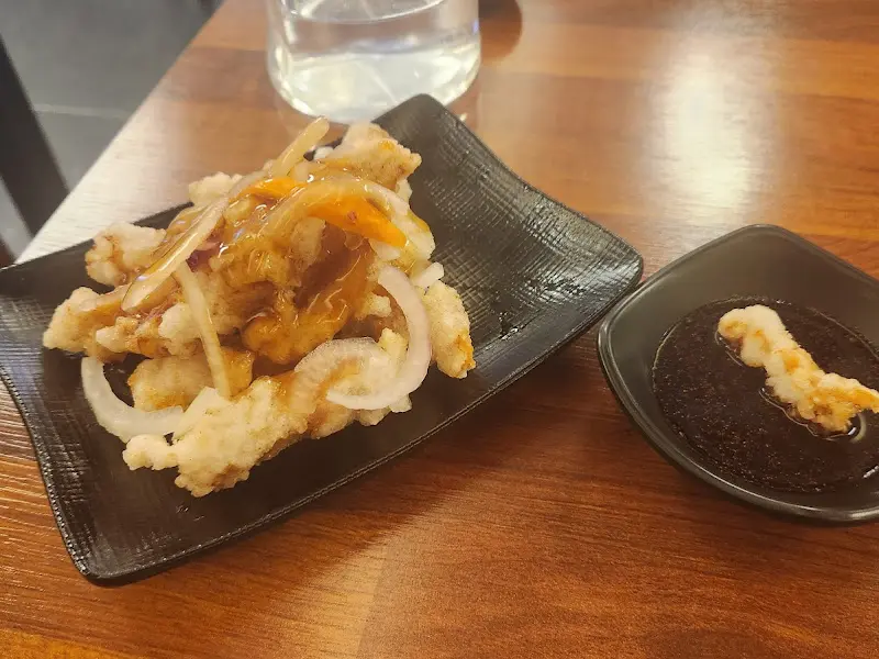 탕수육과 간장 소스가 담긴 작은 그릇이 놓여 있는 테이블 사진