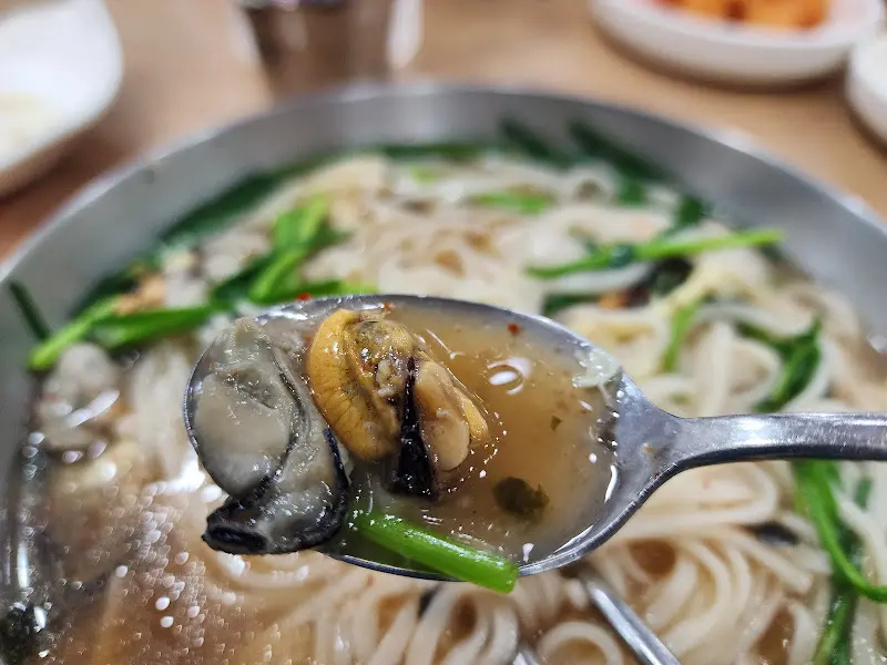 숟가락 위에 올려진 굴과 홍합