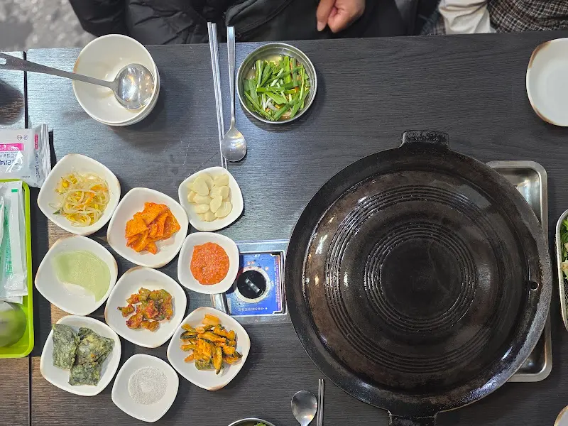 푸짐한 밑반찬과 솥뚜껑 불판