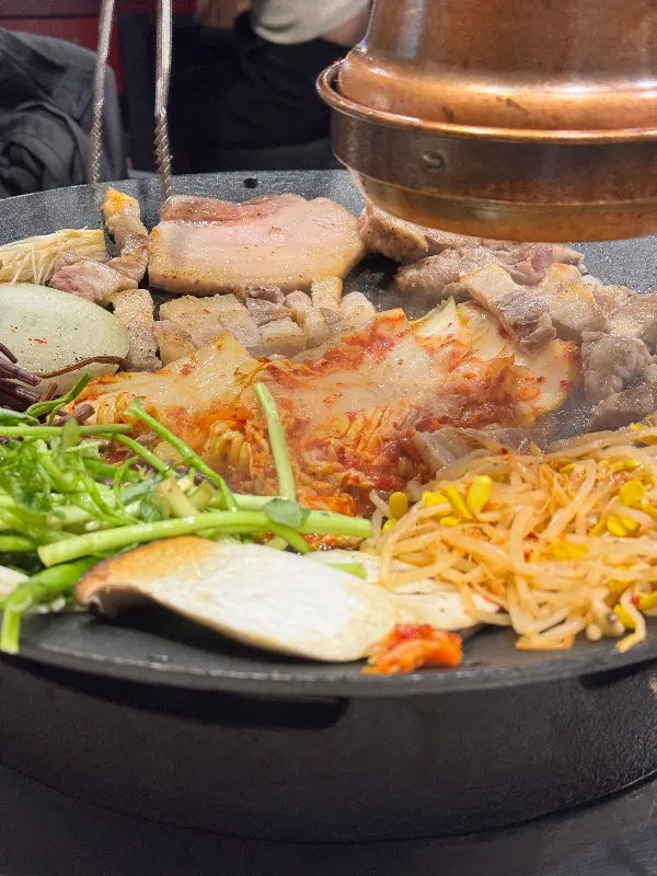 구워진 김치, 콩나물, 미나리와 함께 삼겹살