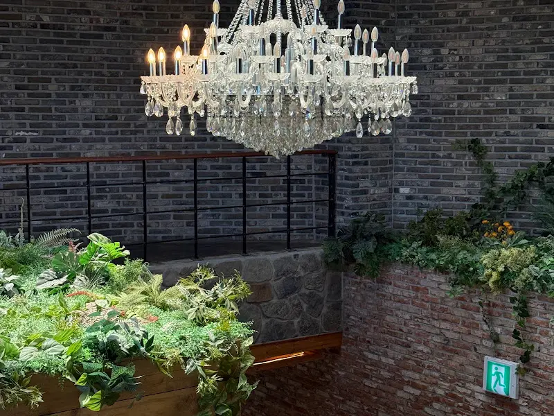 화려한 샹들리에와 푸른 식물이 조화로운 인테리어