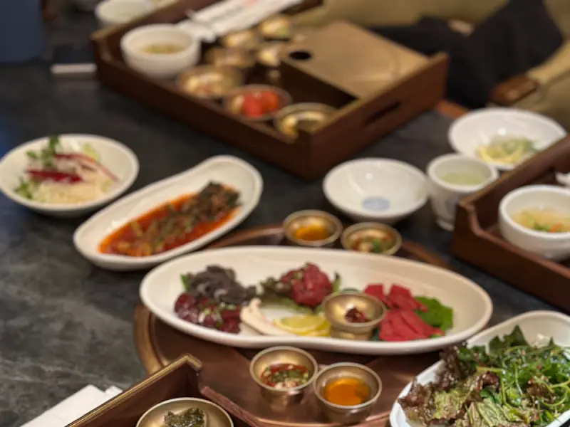 육사시미, 육회, 각종 소스, 샐러드 등 다양한 밑반찬이 정갈하게 담겨있다.