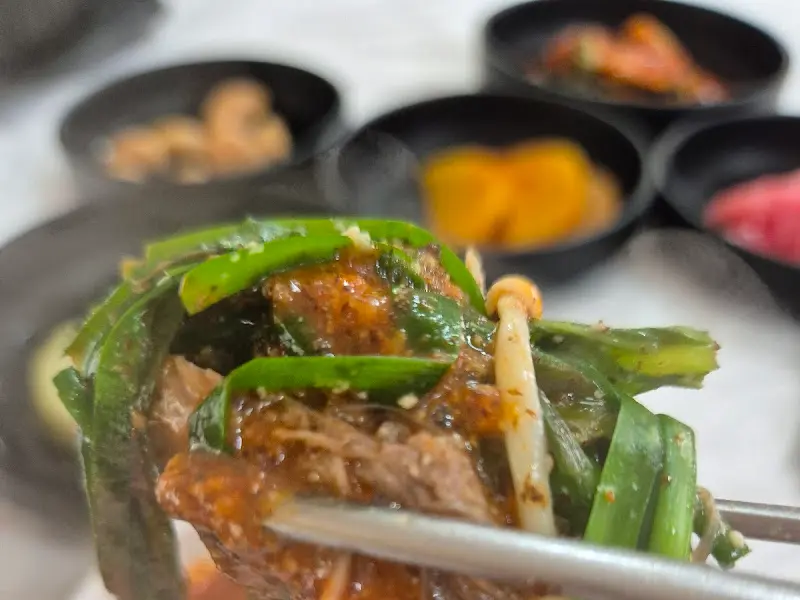 젓가락으로 집어 올린 염소 고기