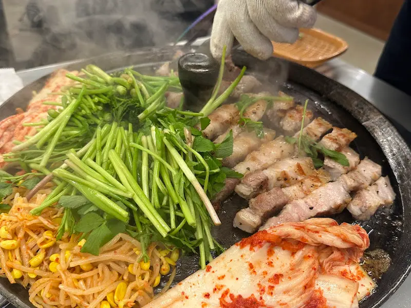 전문가의 손길로 구워지는 삼겹살과 미나리