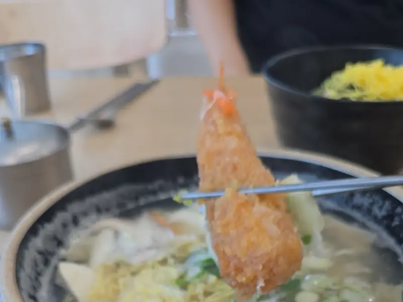 젓가락으로 집어 올린 돈까스 단면이 촉촉해 보인다.