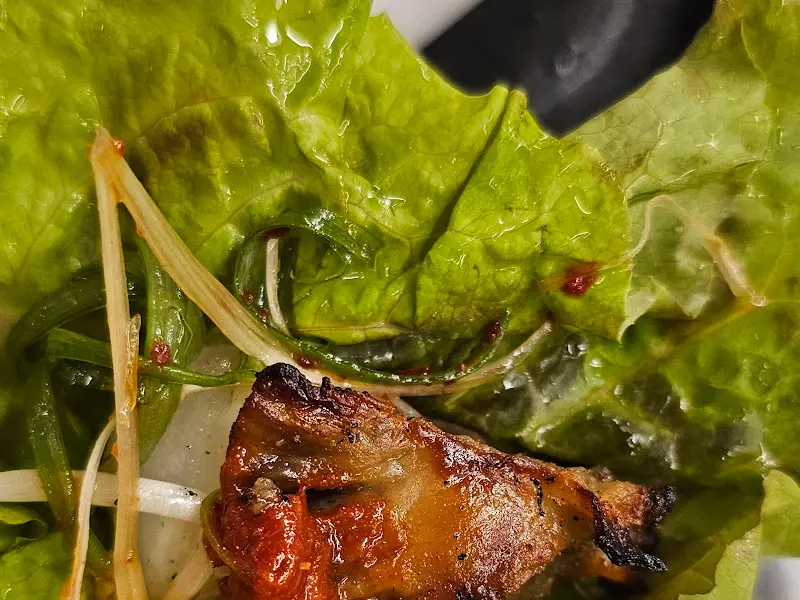 흑돼지와 도래창을 쌈에 싸서 먹는 모습