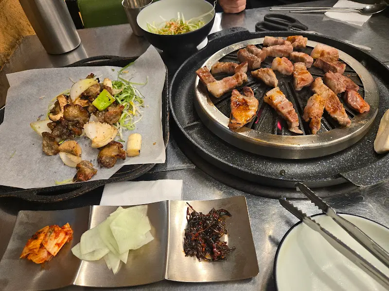 흑돼지, 도래창, 밑반찬이 푸짐하게 차려진 몽실식당 한 상 차림